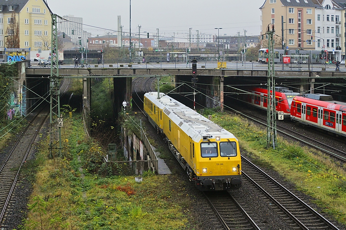 Der Gleismesstriebzug 725 101 ist am 15.12.2023 in Düsseldorf-Wehrhahn auf den Fernbahngleisen in Richtung Duisburg unterwegs. Das linke Gleis gehört zur Güterumgehungsbahn nach Düsseldorf-Lierenfeld, rechts die S-Bahngleise. Im Hintergrund sind die Masten der Strecke von/nach Wuppertal erkennbar, die kurz vor der Einfahrt in den Hauptbahnhof die Strecke von/nach Duisburg überquert.