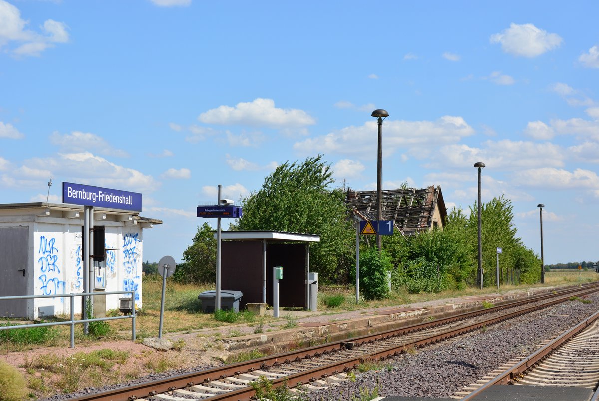 Der Haltepunkt Bernburg Friedenshall ist 3 Wochen vorseiner Schließung schon ziemlich herunter gekommen. Das Abfertigungsgebäude ist abgebrannt und einsturz gefährdet. Das Wartehäuschen und Relaishäuschen beschmiert und das Unkraut wuchert ebenfalls bereits auf den Bahnsteig. Der Haltepunkt wurde am 19.8.2019 geschlossen. Ersetzt wird er durch den neuen Haltepunkt Bernburg Roschwitz welcher zum Fahrplanwechsel am 15.12.2019 in Betrieb gehen soll.

Bernburg 27.07.2019