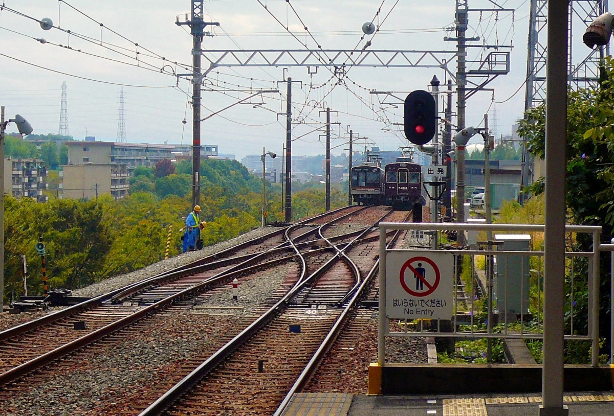 Der Hankyû-Konzern: Während in Ôsaka die Hankyû-Züge die U-Bahn (Sakaisuji-Linie) befahren, kommen umgekehrt U-Bahnzüge auf die Hankyû-Strecke. Im Bild verlässt links ein U-Bahnzug (66909) die Endstation der Stichlinie nach Kita Senri, während Hankyû-Zug 5323 einfährt. 28.September 2009. 
