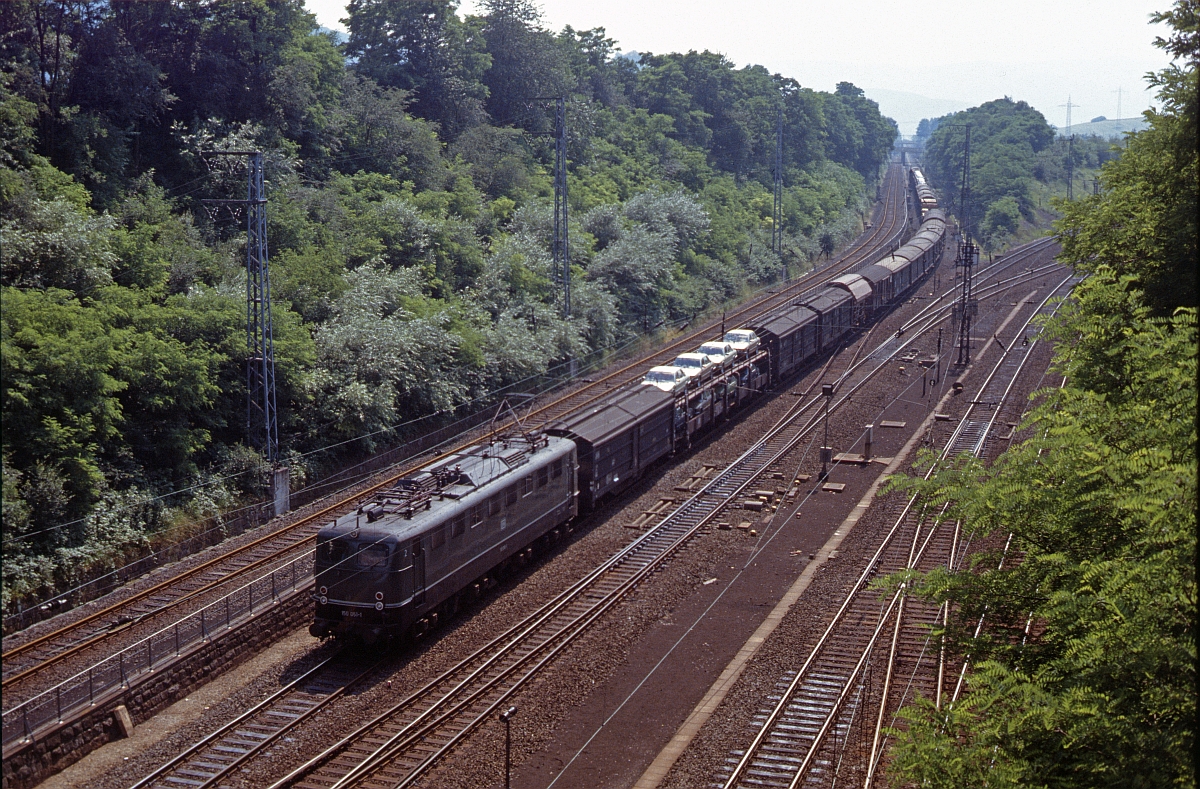 Der heute noch mögliche Fotostandpunkt auf der Feldwegbrücke über die Eichenberger Südausfahrt. 150 051 kommt mit einem bunt gemischten Güterzug aus Kassel (Eichenberg, Juli 1979).