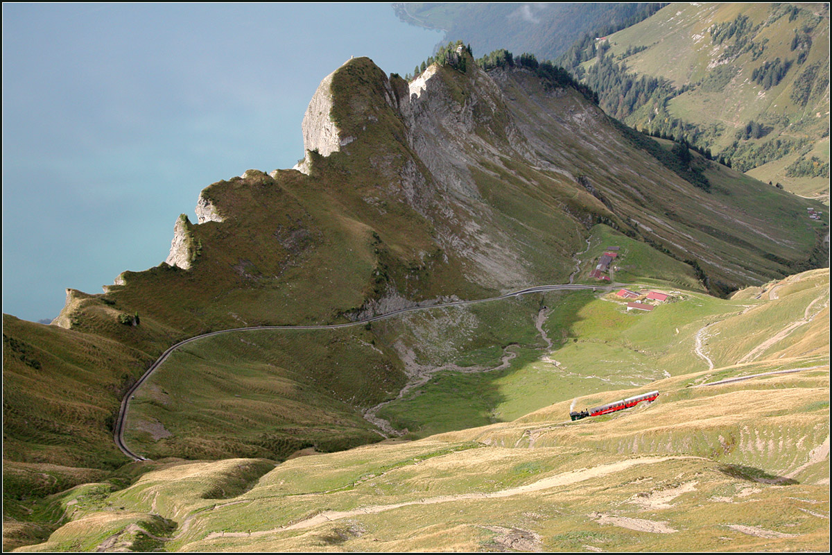 Der Himmel ist ein See -

Der kleine Zug der Brienzer Rothornbahn muss noch den großen Bogen am Berghang hinabrollen um seinen ersten Zwischenhalt 'Oberstafel' zu erreichen. Dieser befindet sich im Bild über der Bahn (in Wirklichkeit ist die Bahn natürlich oben) bei der Häuser-Ansammlung.

Links oben der Brienzer See.

29.09.2013 (M)