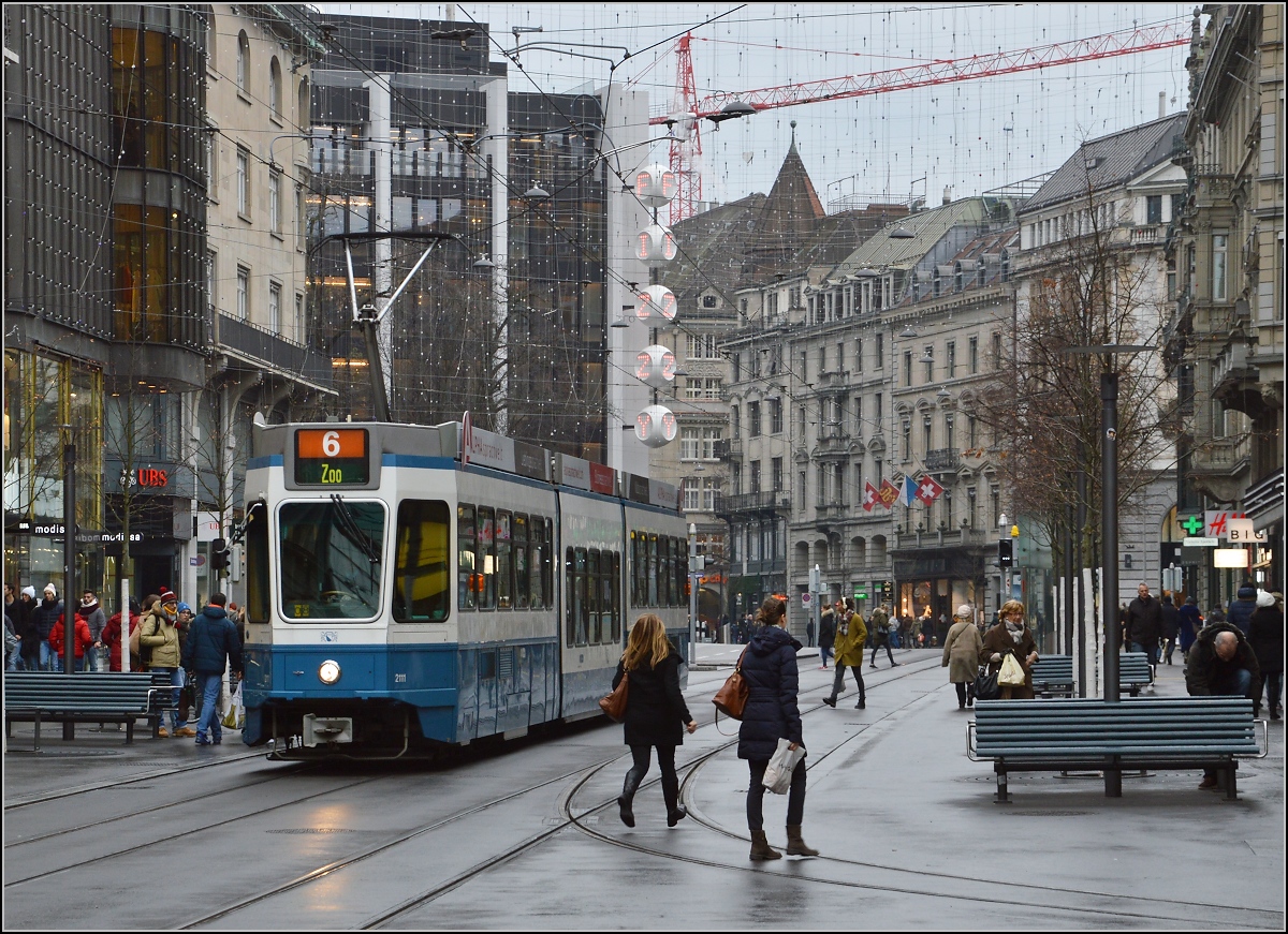 Der Himmel hängt voller Kabel, nicht Geigen... Und Linie 6 nötigt die Passanten zur Eile... Zürich, Dezember 2015.
