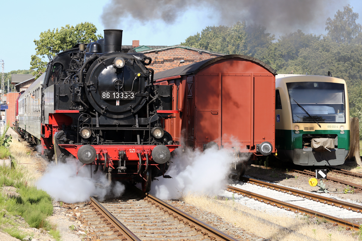 Der historische Zug mit der Dampflok 86 1333 ausfahrend in Bergen auf Rügen nach Lauterbach Mole hat Zeitweise den VT 650 032 ersetzt, der rechts zusehen ist. - 07.07.2018
