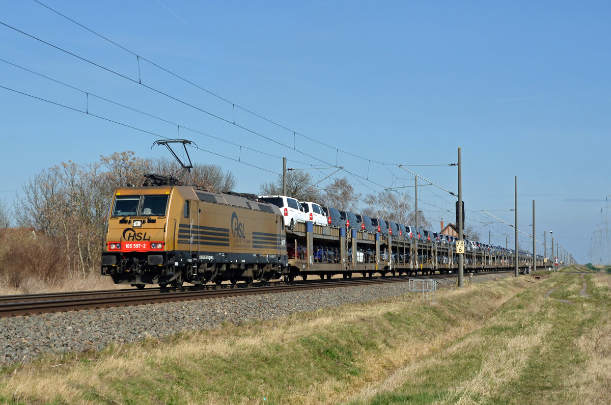 Der HSL-Goldbarren 185 597 schleppte am 26.03.22 einen Toyota-Autozug durch Braschwitz Richtung Halle(S).