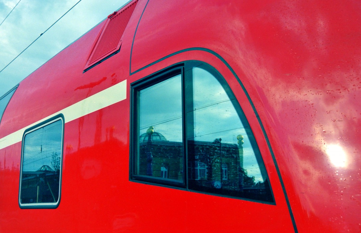 Der Hundertwasser-Bahnhof Uelzen spiegelt sich am 22.06.2001 im Fhrerstandsfenster des Steuerwagens vom RE 24340 (Uelzen–Hamburg).