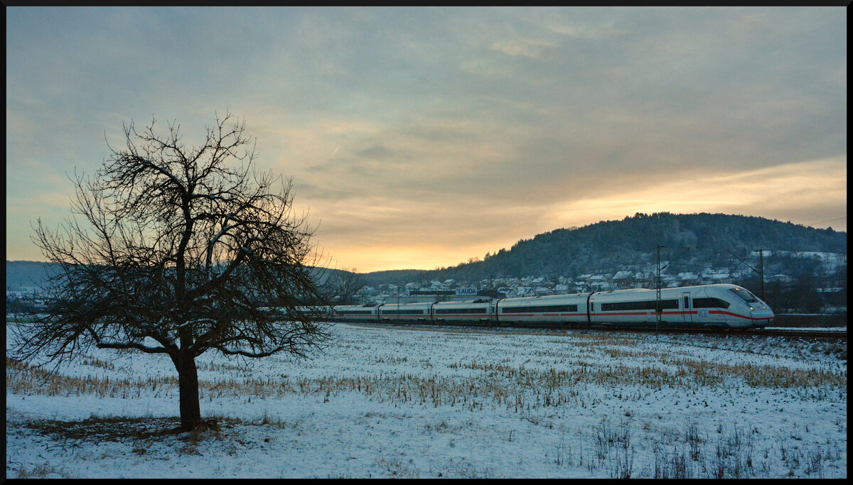 Der ICE 118  Bodensee  fuhr im Januar für drei Wochen von Innsbruck statt nach Dortmund nach Berlin. Dabei nahm er den Weg von Stuttgart über die Frankenbahn nach Würzburg und weiter über Halle/Saale in die Bundeshauptstadt. Am bitterkalten 21.01.2024 legt sich der Zug kurz nach Sonnenuntergang im lieblichen Taubertal bei Lauda in die Kurve.