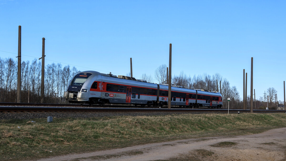 Der internationale Zug 873 Valga - Vilnius der LTG Link kurz nach der Überfahrt über den Fluss Jugla. Zum Einsatz kommen moderne Dieseltriebwagen des Typs Pesa 730ML.
Aufgenommen im April 2026.
