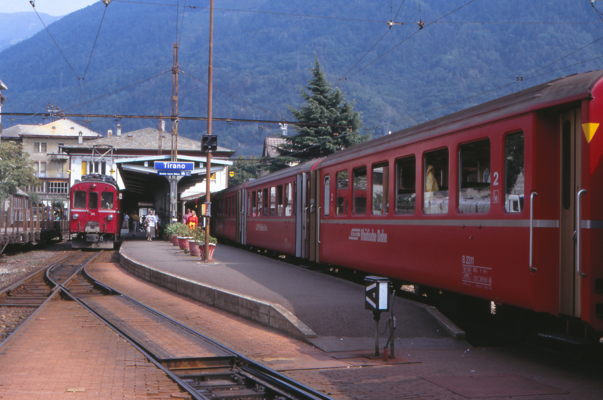 Der italienische Bahnhof Tirano im August 1990: Links steht der Triebwagen ABe 4/4 I 35 der Rhätischen Bahn, rechts steht der Bernina-Express nach Chur. Der Triebwagen stammt aus dem Jahr 1908 und somit aus der Anfangszeit der Berninabahn! 1949 wurde er umgebaut und erst 2010 ausrangiert und als Museumsfahrzeug verkauft.
Tirano, 29. August 1990; Canon A1, Canoscan, Gimp