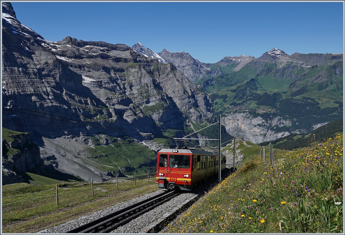 Der Jungfraubahn Bhe 4/8 213 und ein weiterer erreichen in Kürze die Station Eigergletscher. Im Hintergrund, in der Bildmitte ist Mürren zu erkennen.
8. Aug. 2016