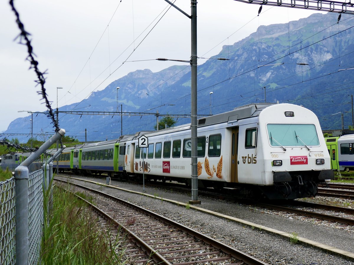 Der Kambly Bt 50 85 80-35 990 mit 3 weiteren EWIII und einer Re 420 am 20.7.17 bei Interlaken Ost abgestellt, die Kamera wurde durch einen Zaun gehalten.