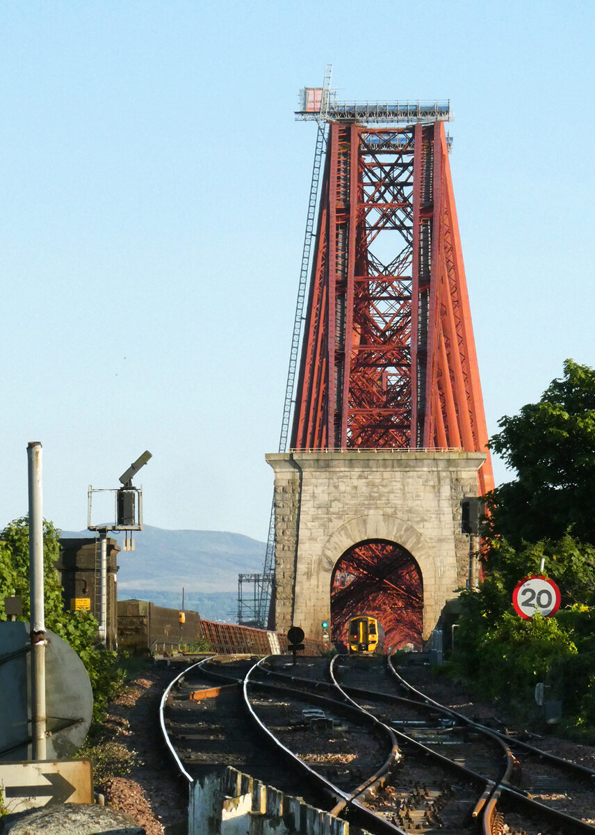 der kleine Dieseltriebzug 158732 verschwindet auf seinem Weg nach Edinburgh im gigantischen Bauwerk Firth of Forth - Bridge. North Queensferry, 9.5.2025