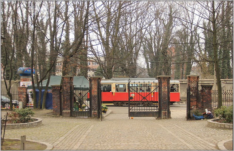 Der Konstal N Wagen auf der Linie 38 in Bytom nahe der Haltestelle Cmentarz Mater Dolorosa, durch das Friedhofstor gesehen. März 2018