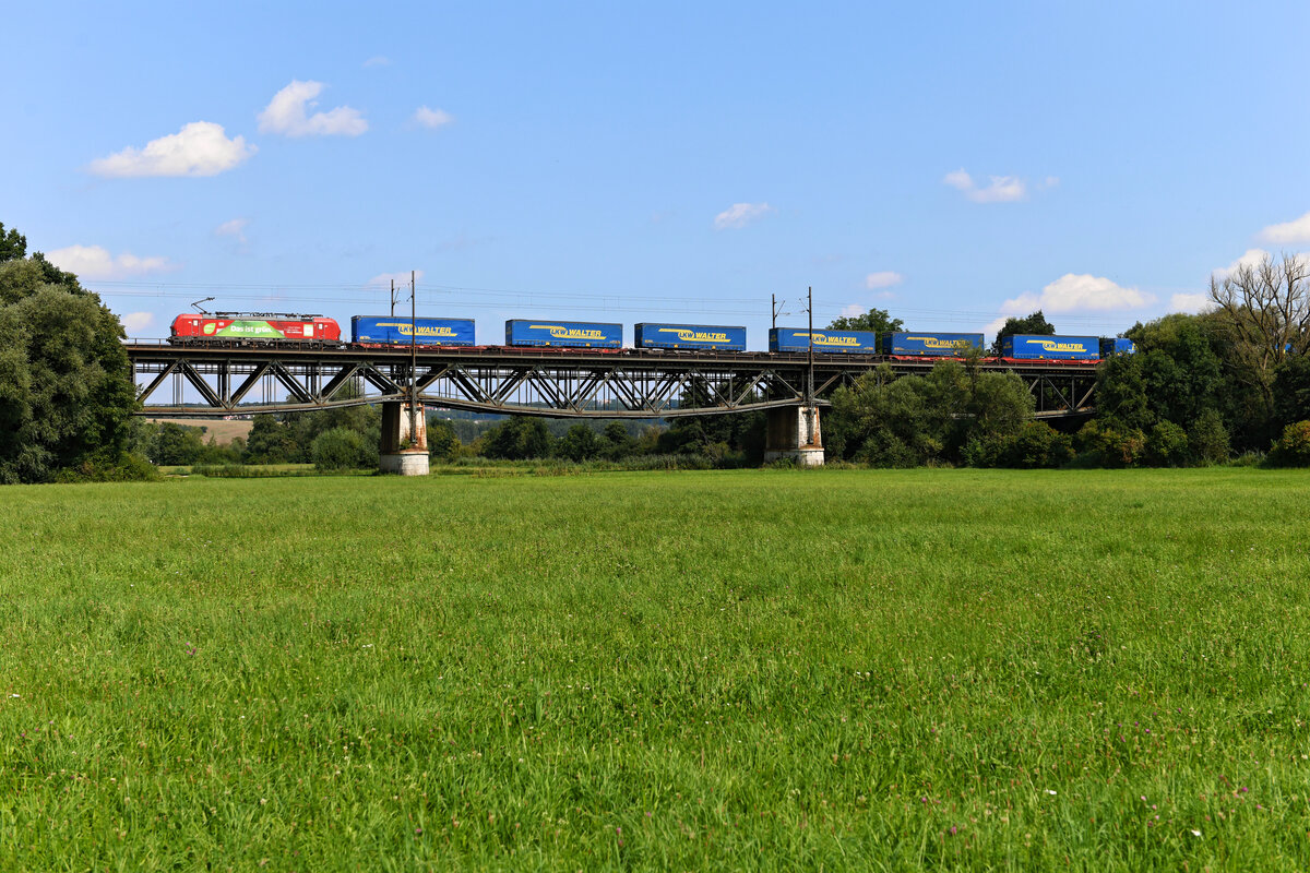 Der KT 42154 von Verona Q.E. nach Rostok Seehafen wurde am 21. August 2021 über den gesamten Laufweg hinweg von 193 301 befördert. Der Vectron von DB Cargo verweist mit seiner Seitenbeschriftung auf eine Energiesparolympiade unter Lokführern, bei der die Einsatzstelle Hamm  Gold  gewonnen hat. Entstanden ist die Aufnahme des einheitlich mit Aufliegern der Spedition LKW Walter beladenen KLV-Zuges beim Überqueren der Wörnitzbrücke bei Donauwörth.