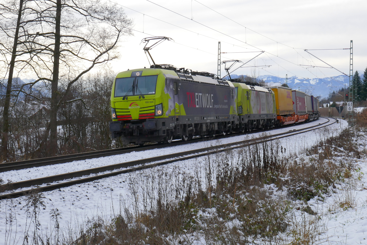 Der  Leitwolf  der TXL, Vectron 193 554 (mit 193 551 an zweiter Stelle) hat mit einen Zug des kombinierten Ladungsverkehrs gerade den Bahnhof Rosenheim Richtung München durchfahren, am winterlichen Freitag, den 10.Dezember 2021.