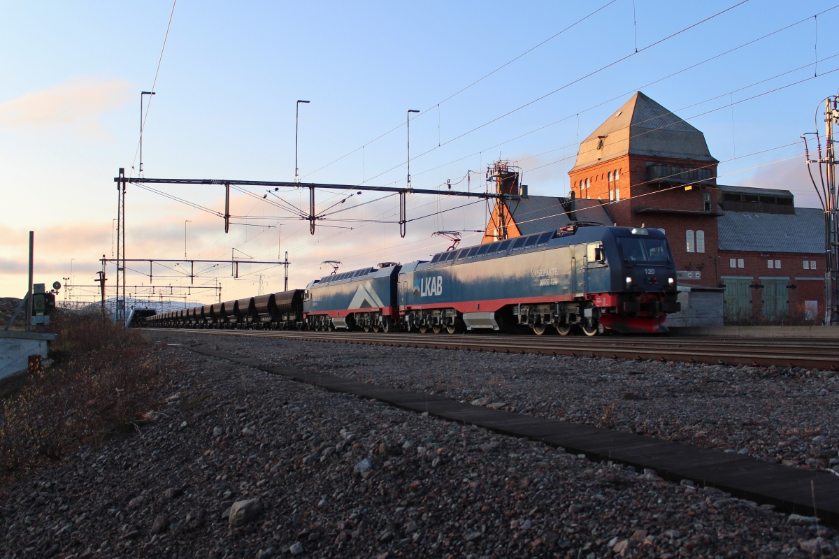 Der letzte Erzzug bei Tageslicht durchfährt am Nachmittag des 11.10.2019 den Bahnhof Vassijaure kurz vor der Grenze nach Norwegen.