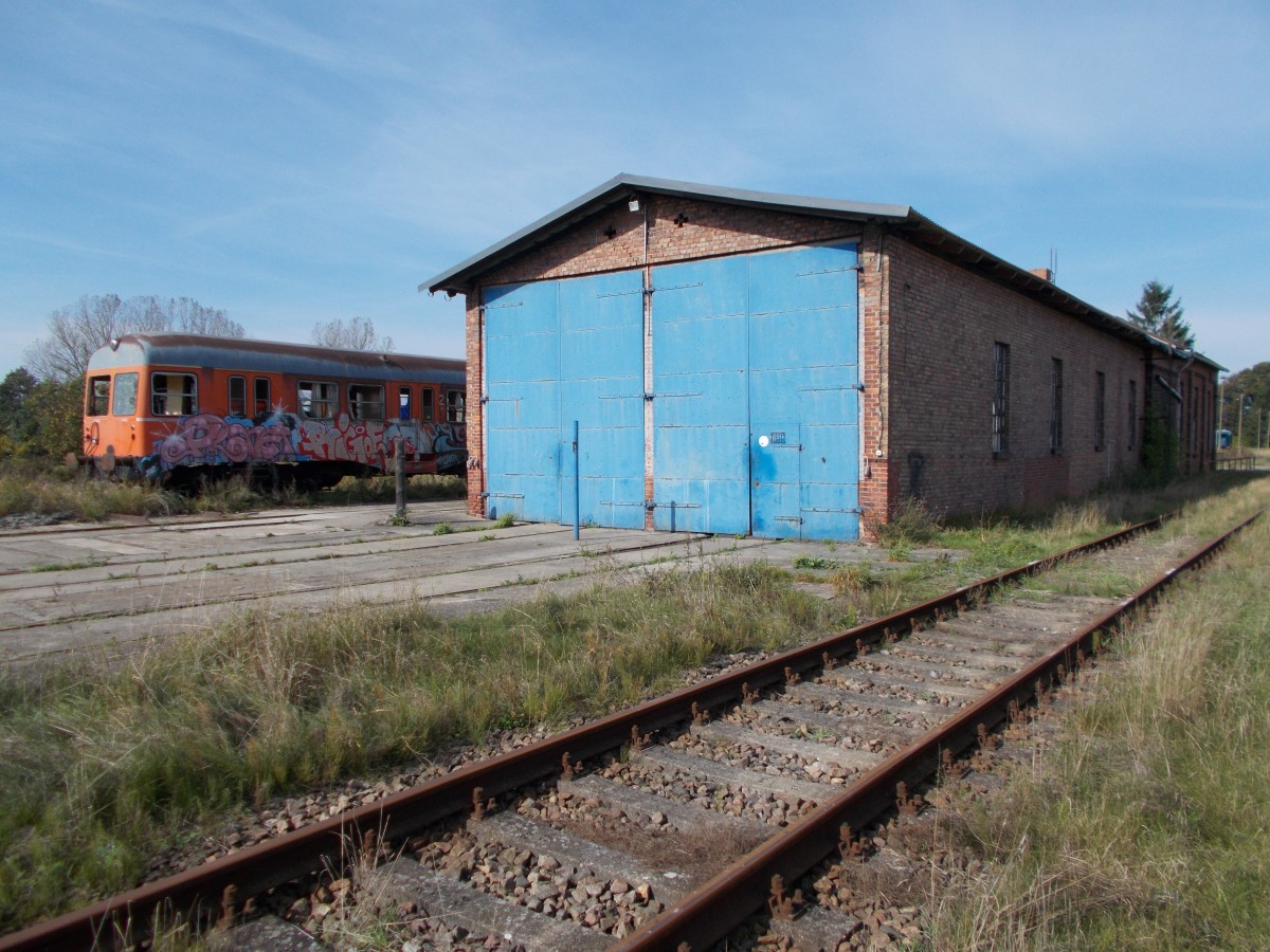 Der Lokschuppen in Putlitz war lange Zeit das Zuhause von der PEG.Nach deren Abzug ließ die PEG neben ein paar Schrottwagen auch einem im Hintergrund zuerkennenen NE 81 zurück.Aufnahme am 28.September 2014.