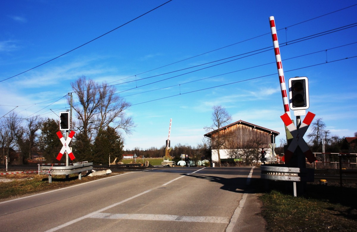 Der mit Halbschranken ausgestattete Bahnübergang Happing südlich von Rosenheim (Inntalbahn)am 15.02.2014 in Grundstellung...