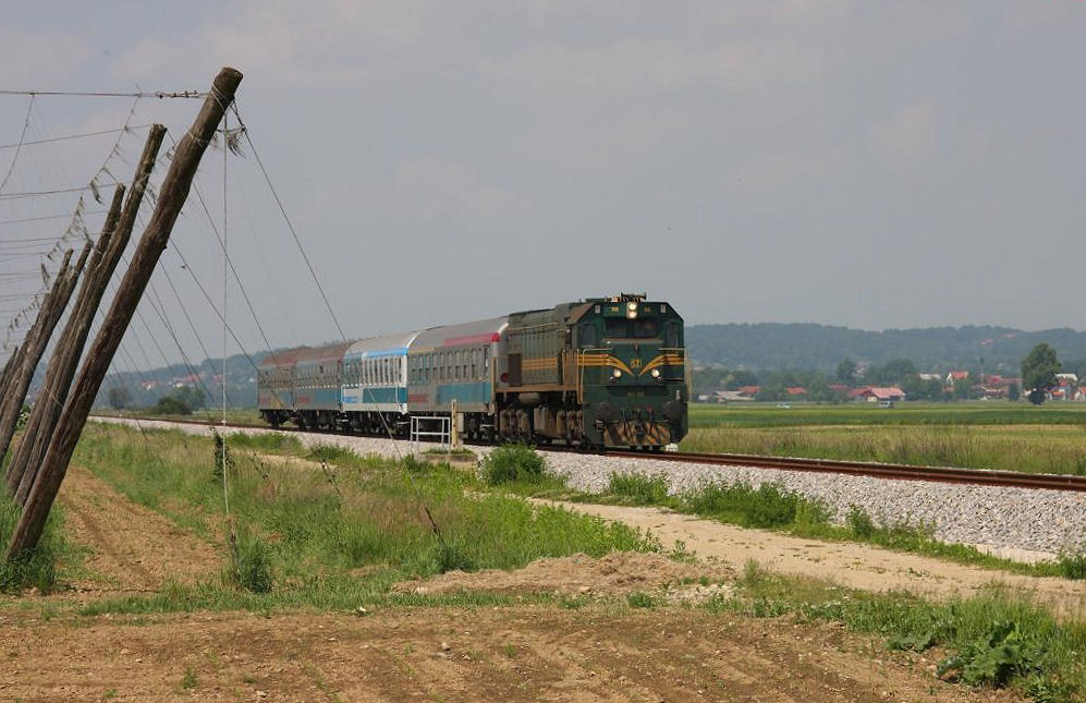 Der mit der SZ Diesellok 664106 bespannte Intercity 147 Citadelle nach Budapest
fährt am 19.5.2011 mit geringer Geschwindigkeit an den Hopfenfeldern westlich von Cakovac entlang. Die langsame Fahrt ist auch geboten; denn die nächsten folgenden Bahnübergänge sind nur mit Andreas Kreuzen gesichert!