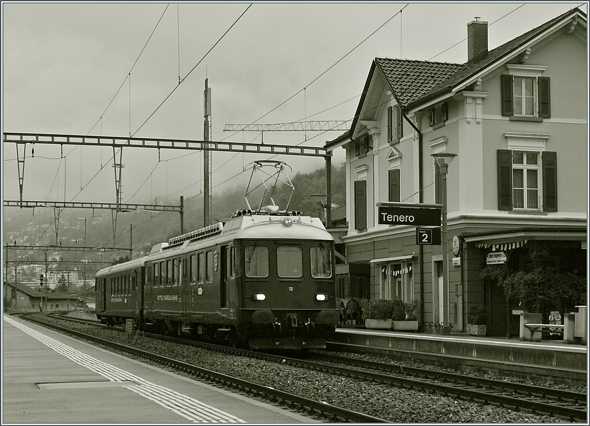 Der MThB ABDe 4/4 N° 12  Weinfelden  mit dem BDt 205 passiert auf seiner Fahrt Richtung Bodensee den Bahnhof von Tenero. 
15. Sept. 2013