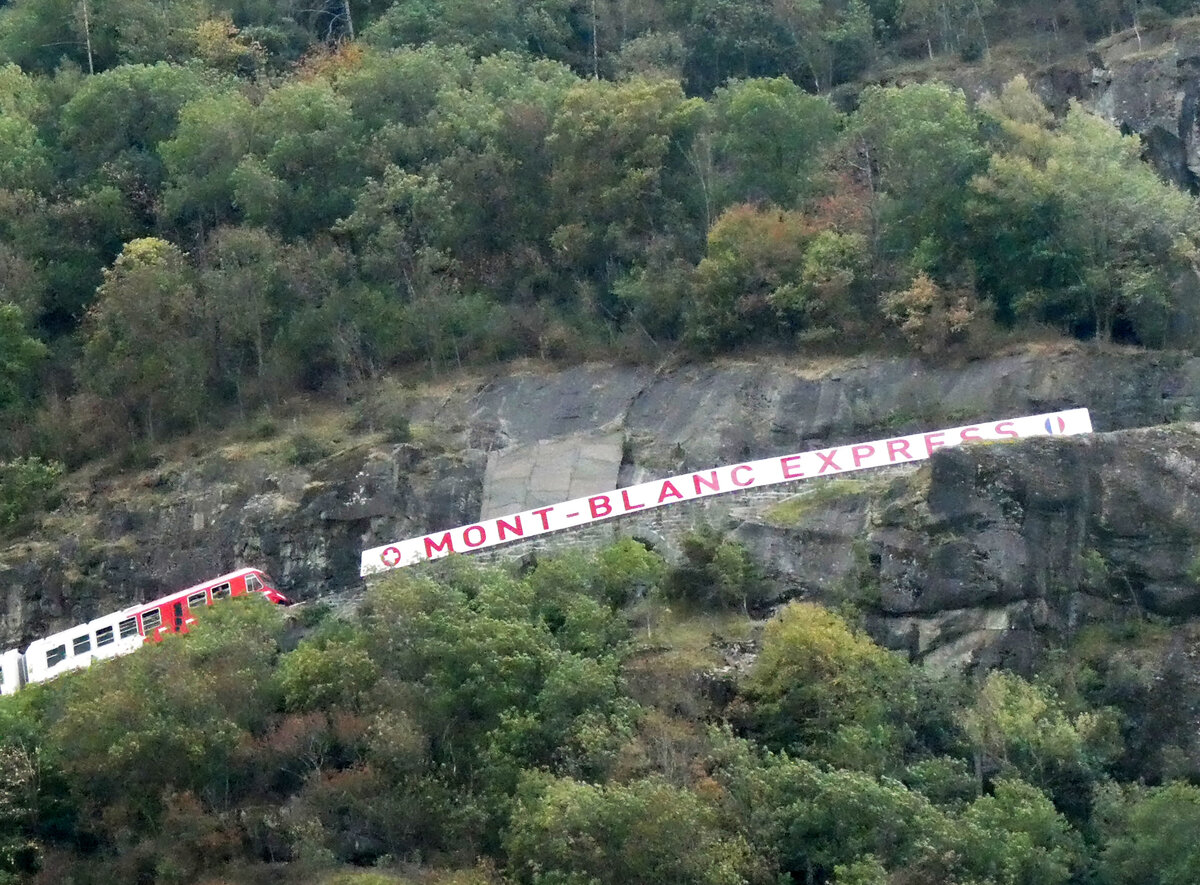 Der Name sagt es: der Mont-Blanc-Express fährt bergwärts von Martigny in Richtung Le Chatelard - Vallorcine (F). Das Foto wurde vom Talboden in Vernayaz aus gemacht. Vernayaz, 25.8.2025