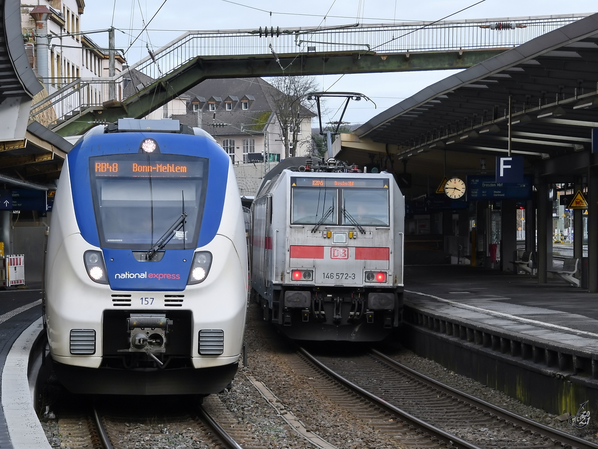 Der National Express-Elektrotriebzug 157 ist als RB48 nach Bonn-Mehlem unterwegs, der 146 572-3 geschobene IC2045 nach Dresden Hbf beim Halt am Hauptbahnhof Wuppertal. (Februar 2021)