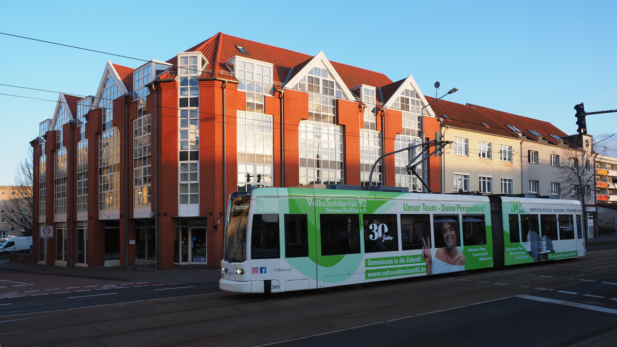 Der neu folierte Wagen 303 mit Werbung für die  Volkssolidarität 92  fährt vor der Geschäftsstelle des Vereins auf der Linie 1 Richtung Hauptbahnhof.

Dessau, der 19.02.2022