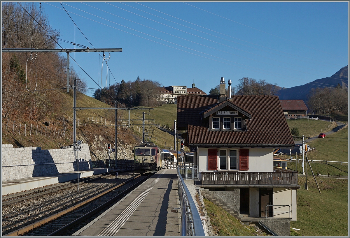 Der nördliche Bahnhofskopf von Les Sciernes liegt nicht nur in einer bereits  beträchtlichen Neigung, sondern auch in einer sehr engen Kurve. 
Im Bild die MOB GDe 4/4 6006 mit ihren vier Wagen als PE 2111 auf dem Weg von Zweisimmen nach Montreux.

26. Nov. 2020