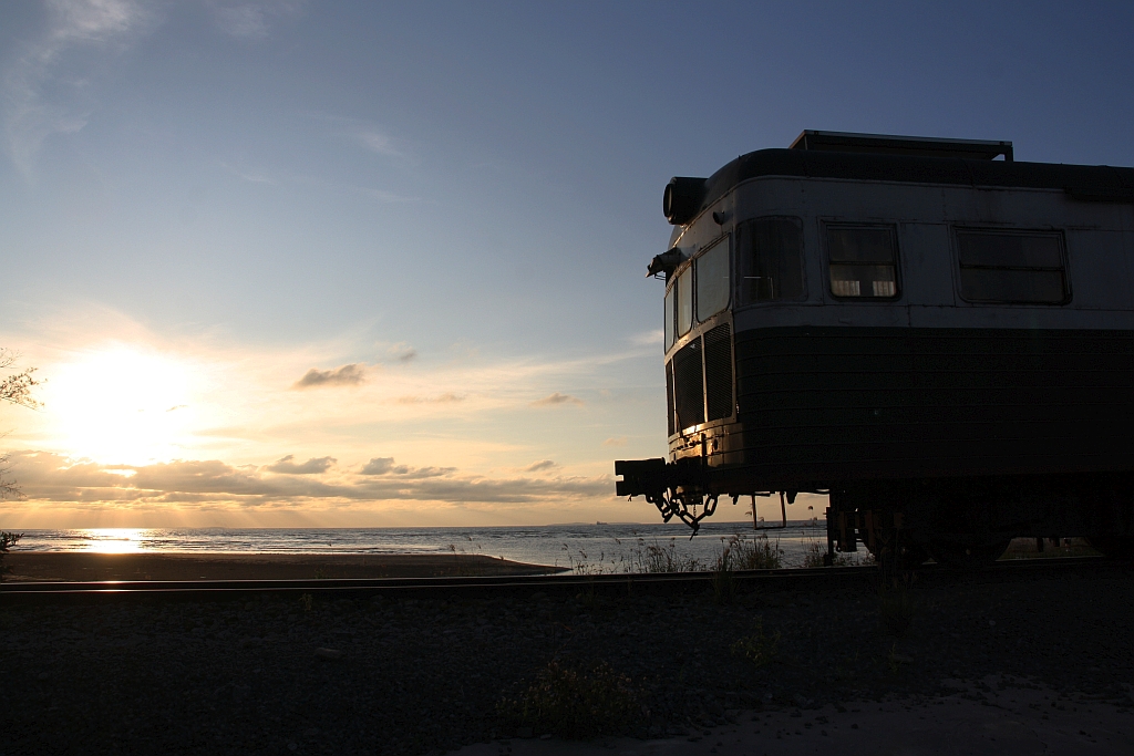 Der nur an Samstag verkehrenden Touristenzug  TRAIN TO MUARA SUNGAI BENONI  ist für Romantiker und frisch Verleibte gedacht, da das Ziel der Fahrt das Beobachten des Sonnenuntergangs ist. - Das Bild vom 15.Februar 2025 zeigt so eine romantische Stimmung mit Sonnenuntergang und der Silhouette des zum Kitchen Car umgebaute JKNS 310x (ex NBR 54, Hersteller: Wickham, Baujahr: 1956, Fabr.Nr.: 7624).