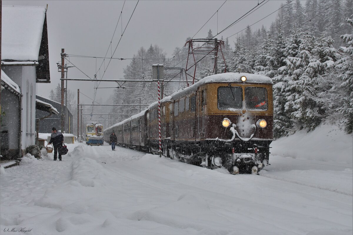 Der Ötscherbär R6891 von St. Pölten Hbf nach Mariazell war am 2.12.2023 von der E7 (ex 1099.007) und der E10 (ex 1099.010) bespannt und macht sich hier im dichten Schneefall in Mitterbach auf den Weg der letzten Etappe nach Mariazell.