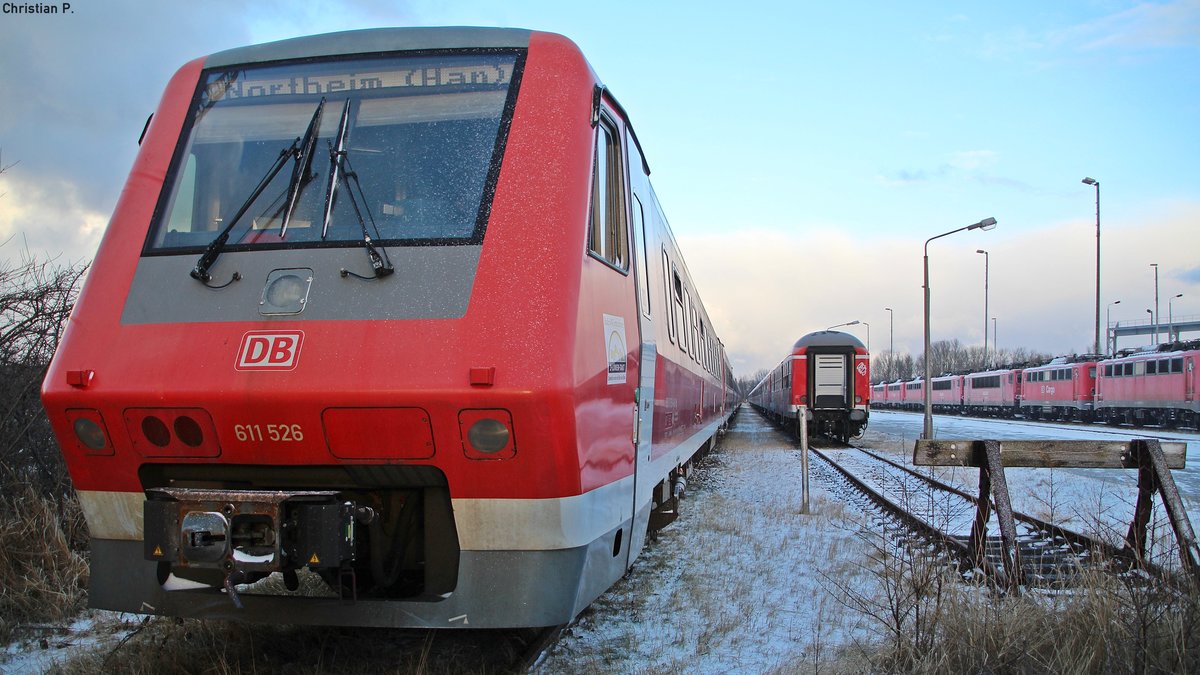 Der Pannolino (dt. Windel), abgeleitet aus dem Vorgängermodell VT 610  Pendolino , hatte als rein  Deutsches  Fabrikat seine Schwierigkeiten sich gegenüber dem  Italiener  zu behaupten, da er mit im Militär verwendeter Technik ausgestattet war, die damals wie heute sehr Fehler belastet ist.
Der 95 80 0611 026-5 D-DB/95 80 0611 526-4 D-DB ist einer von nur rund fünfzig VT 611 (Verbrennungstriebwagen mit Neigetechnik) die gebaut wurden, bis der Großauftrag der Bundesbahn storniert wurde. Seit dem 15.12.15 ist nun das Stillstandsmanagement der DB die letzte Heimat der Neigetechnik Flotte.
Die zuletzt im Bw Ulm bei der DB ZugBus Regionalverkehr Alb-Bodensee GmbH beheimateten 16 Triebzüge der Baureihe 611.0 die im SSM Mukran stehen, haben in den Zug Ziel Anzeigen (ZZA) Northeim (Han) und Itzehoe stehen.
leider wird ein Teil der Triebwagen von Mukran aus nurnoch eine Reise antreten, wenn sie nicht vor Ort zerlegt werden.
Auffällig ist, das Verbrennungstriebwagen mit Neigetechnik bei der DB keine große Karriere zu erwarten haben.
Der 611 als zeite Neigetechnik Baureihe der Bundesbahn hat noch gut 21 Jahre sich behaupten können.
Die VT 612 werden in absehbarer zeit das Selbe schiksahl erleiden, und die ICE TD (Baureihe 605) hat nach Verhältnismäßig kurzer Betriebszeit ein Kaotisches Ende (bei der DB) ereilt.
Hoffentlich werden die verbleibenden  Muhikaner  noch eine Weile fahren.

(Kein Gleisbereich, vom Gehweg aus Fotografiert)