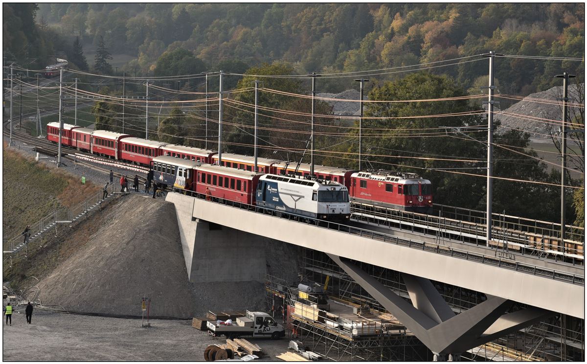 Der Pressezug mit Ge 4/4 III 649  Lavin , ein B (fürs WC) und der Stiva Retica Barwagen stehen auf der neuen Brücke, währenddem dahinter RE1752 mit der Ge 4/4 II 625  Küblis  über die alte Brücke fährt. Während der Sanierung der alten Brücke werden in Kürze sämtliche Züge die neue Brücke befahren. Dazu erkennt man hinter dem Barwagen die provisorische Weiche für die Einführung der Oberländer Linie. (18.10.2018)