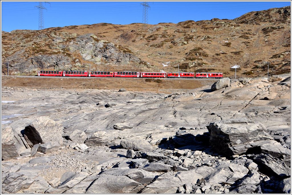 Der R1625 mit den beiden ABe 4/4 III 54  Hakone  und 55  Diavolezza  und den Wagen des Bernina Express ab Chur in der Steinwüste am Ufer des Lago Bianco.(10.12.2015)