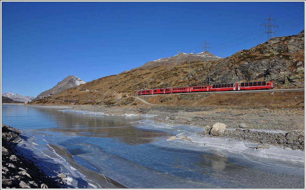 Der R1640 aus Tirano erreicht bald den höchsten Punkt der RhB in Ospizio Bernina 2253m. Die Reisenden wie auch der Fotograf geniessen die traumhafte Aussicht auf den eisigen Lago Bianco. (10.12.2015)