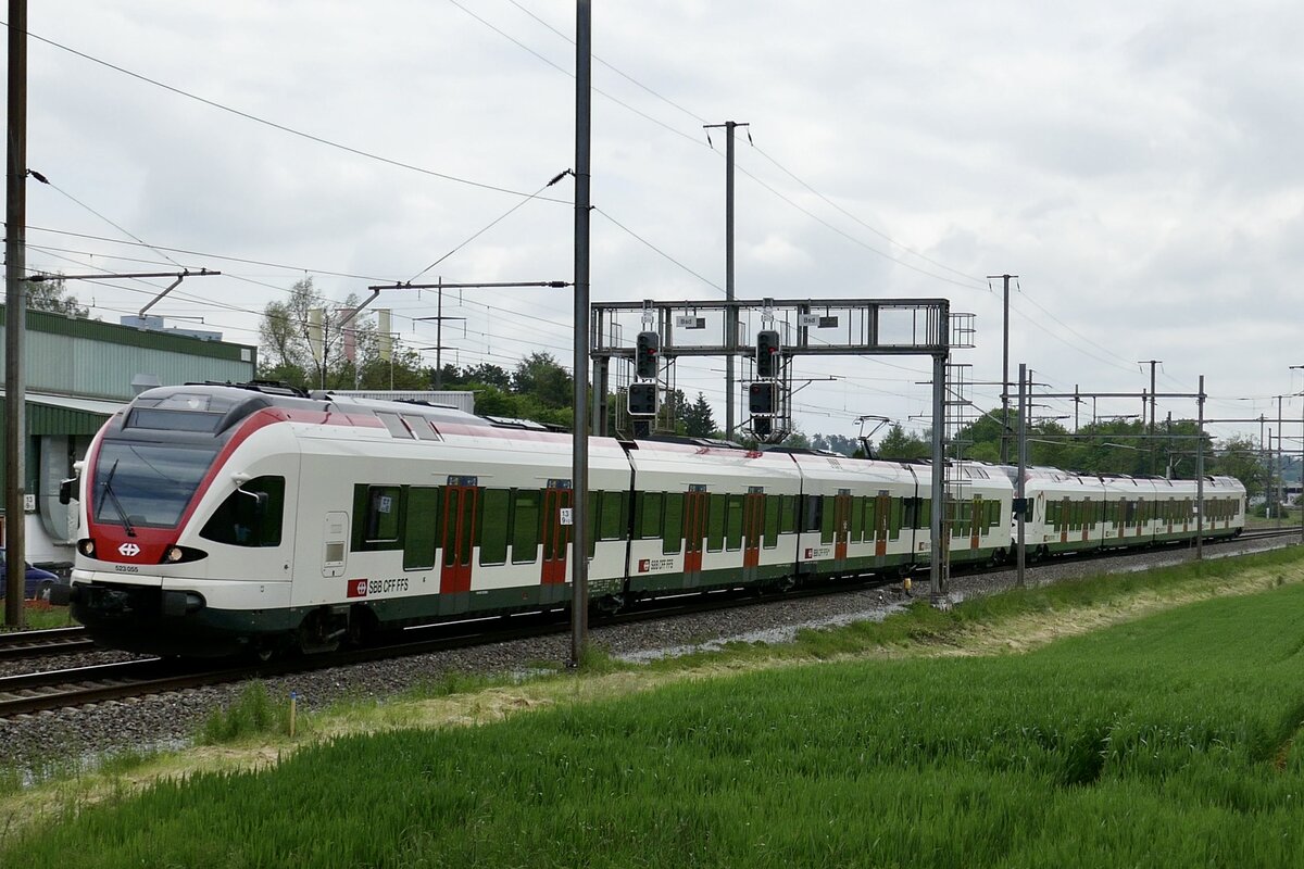 Der RABe 523 055 und RABe 521 016  Sissach  unterwegs vom Abstellgleis im Bahnhof Bassersdorf zum Flughafen Zürich um dann als Flugzug nach Basel zu fahren, am 18.5.23 bei Bassersdorf.