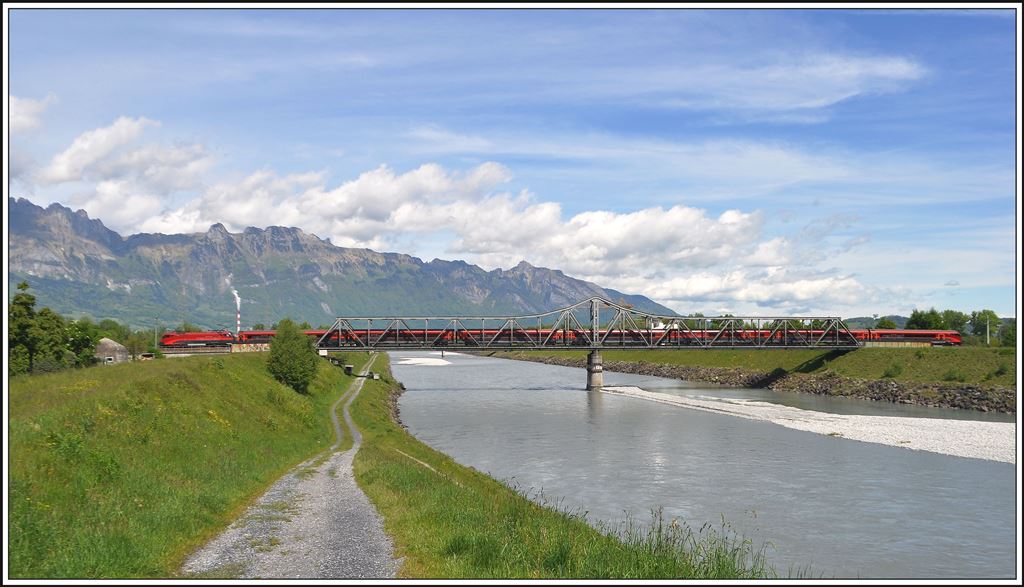 Der Railjet 364 überquert die Grenze zwischen der Schweiz und dem Fürstentum Liechtenstein auf der Rheinbrücke bei Buchs SG. Im Hintergrund ist die Alpsteinkette zwischen der Saxerlücke und dem Hohen Kasten zu sehen. (08.05.2014)