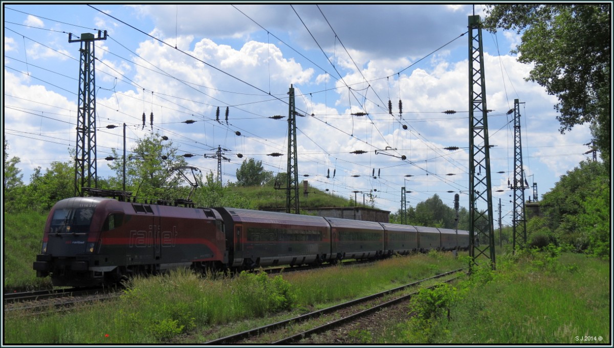 Der Railjet der ÖBB kommt aus Richtung Györ angerauscht und fährt hier gerade am Stadtrand von Komárom vorbei.Szenario vom 20.Mai 2014 (Ungarn).