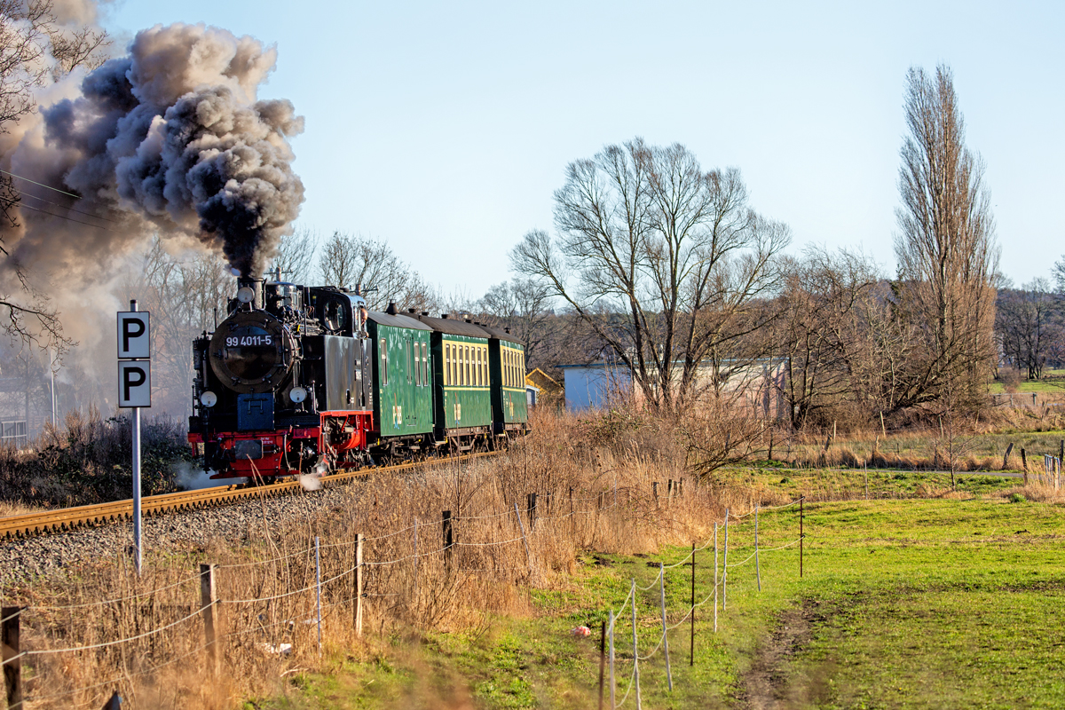 Der Rasende Roland mit der Lok 99 4011 zwischen beschranktem und unbeschranktem Bahnübergang in Seliin. - 05.02.2020
