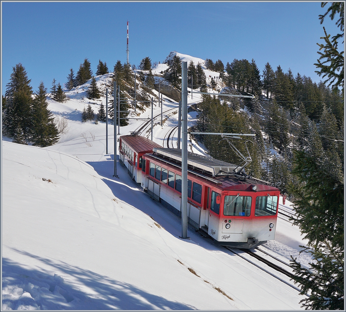 Der RB BDhe 4/4 N° 21 von Rigi Kulm kommend erreicht in Kürze die Station Rigi Staffel. Der Triebwagen wurde Von SLM BBC 1986 gebaut. Obwohl damals die ARB und die VRB noch selbständig waren, wurden die vier Triebwagen N° 15 und 25 ARB sowie die VRB 21 und 22 so konstruiert, dass sie auf beiden Strecken eingesetzt werden können. Wohl der (VRB)-Farbe wegen, werden die Triebwagen 21 und 22  Beeri  genannt. 
24. Feb. 2018