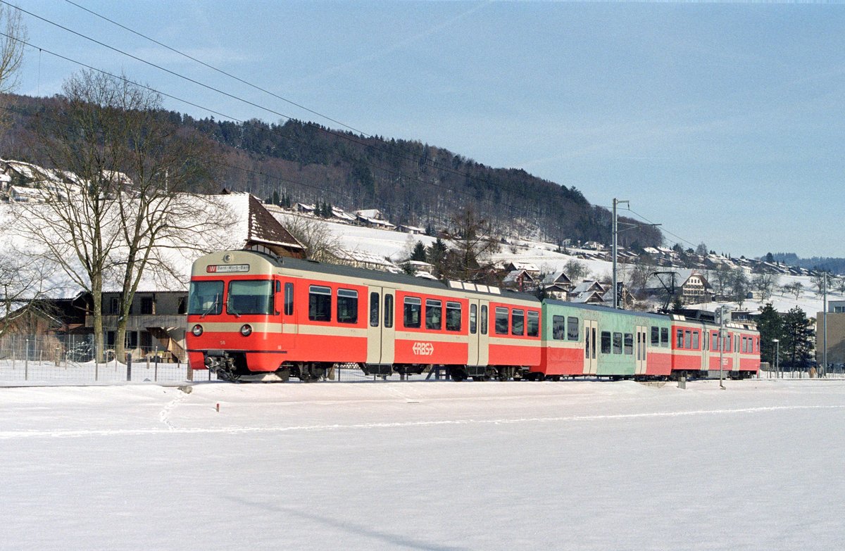 Der RBS-Be 4/12 58 am 30. Januar 2004 auf der damaligen Linie W kurz vor Stettlen. Auf dem Niederflur-Mittelwagen B 49 sind rote Strichmännchen zu sehen, welche als künstlerische Gestaltung das Design des Wagens verschönern sollten.