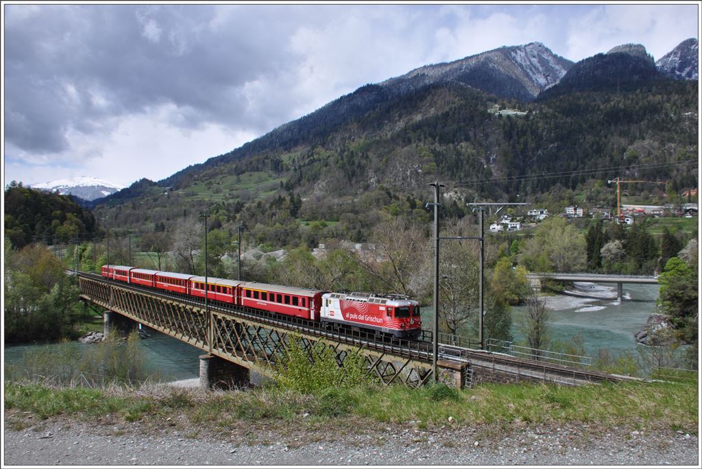 Der RE1740 aus Disentis mit der Ge 4/4 II 633  Zuoz  auf der Hinterrheinbrücke bei Reichenau-Tamins. (27.04.2016)