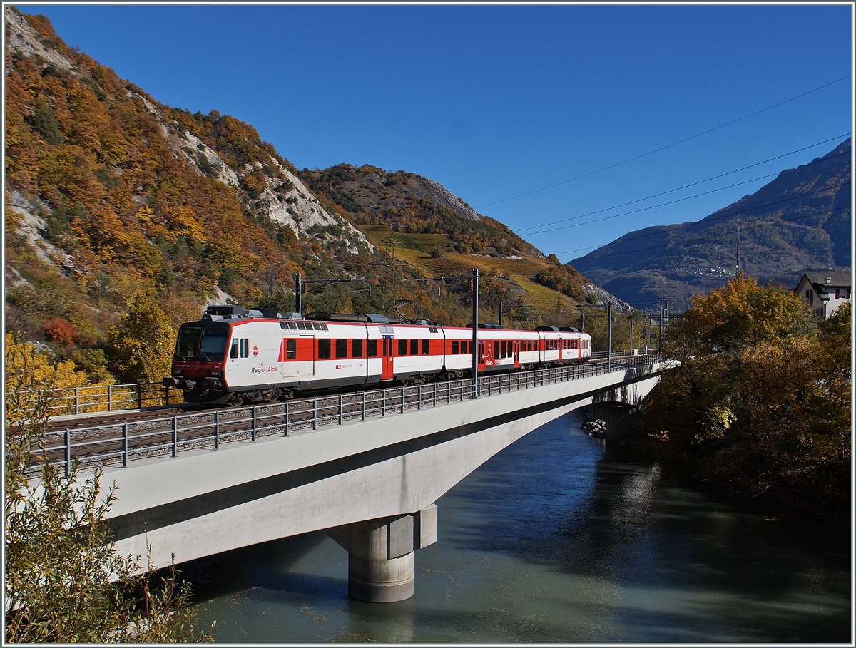 Der  Regio-Alpes  Regionalzug 6117 Monthey - Brig überquert die Rohne und erreicht unmittelbar danach Leuk. 
26. Okt. 2015
