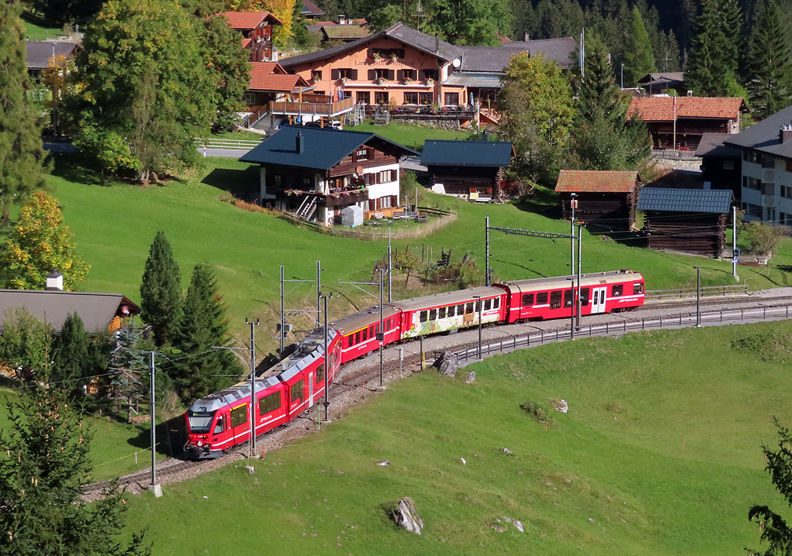 Der Regionalzug von Arosa nach Chur fährt in den Bahnhof Litzirüti ein. Das Foto wurde von einem Parkplatz nahe der Strasse aus gemacht. Litzirüti, 12.10.2023
