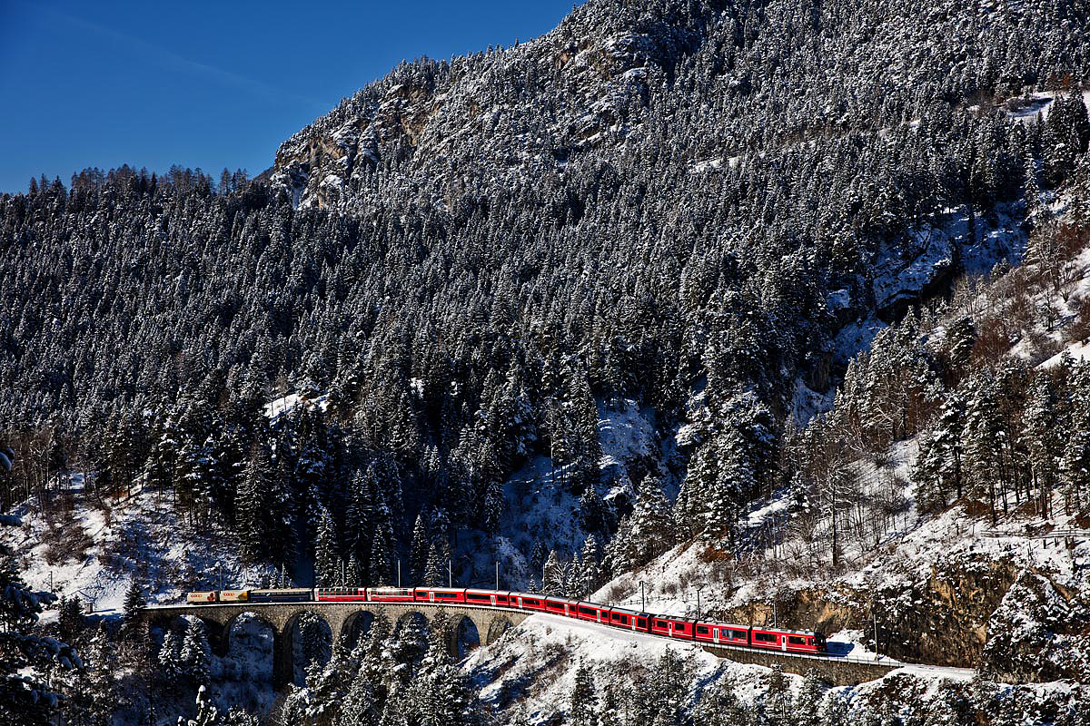Der RhB Triebzug ABe 8/12 3509 fährt mit einem Re aus Chur nach St.Moritz über das Schmittentobelviadukt in Filisur.Bild vom 9.1.2017