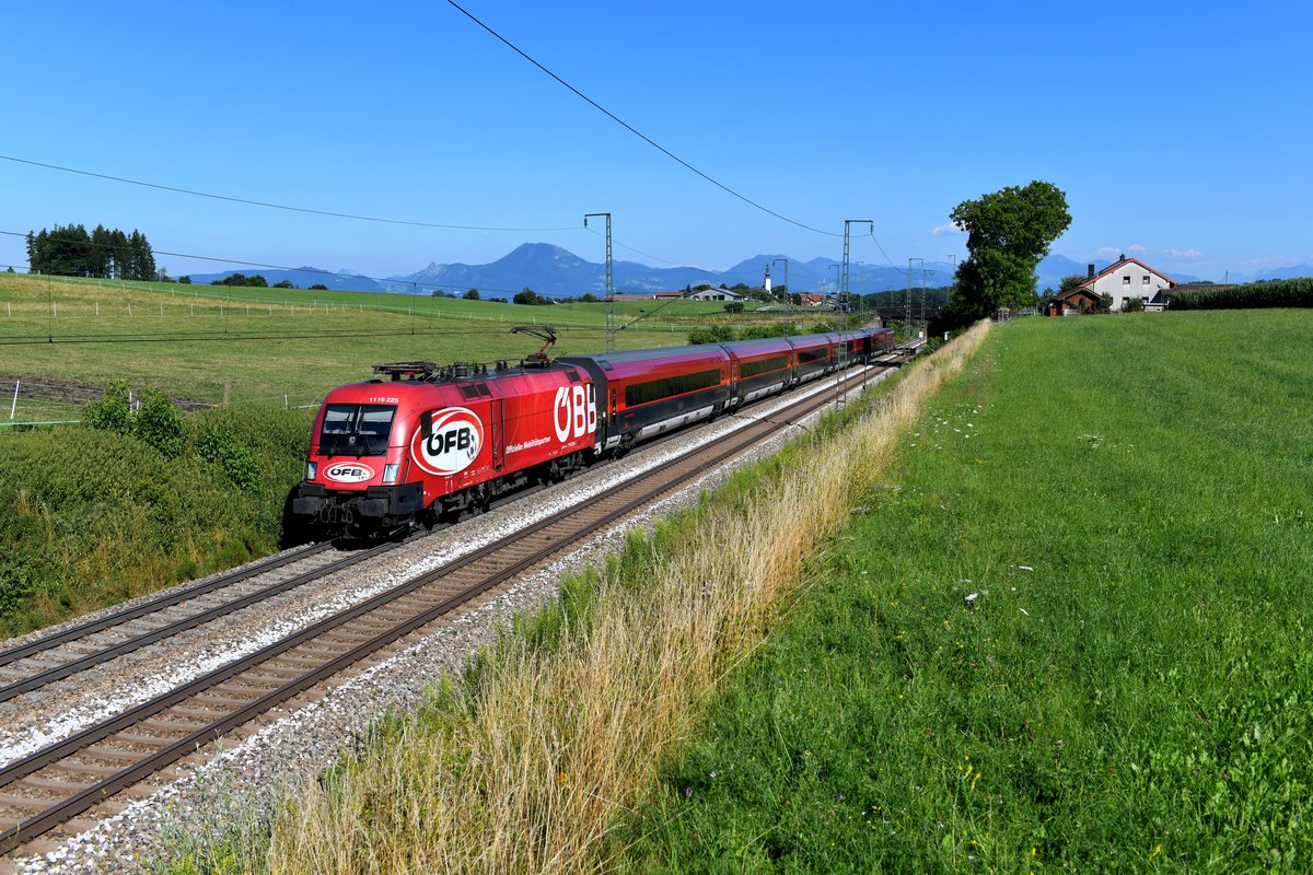 Der RJX 864 vom Flughafen Wien nach Bregenz wurde am 23. Juli 2019 von 1116.225 geführt. Die Lok zeigte zum Aufnahmezeitpunkt immer noch die äußere Gestaltung, mit der auf die Kooperation zwischen der ÖBB und dem Österreichischen Fußballbund hingewiesen werden sollte. Die dazugehörige Wagengarnitur hatte bereits seit geraumer Zeit ihre Folien verloren. In flotter Fahrt wird der Korridor durcheilt, nächster Halt ist erst wieder in Wörgl in Tirol. 