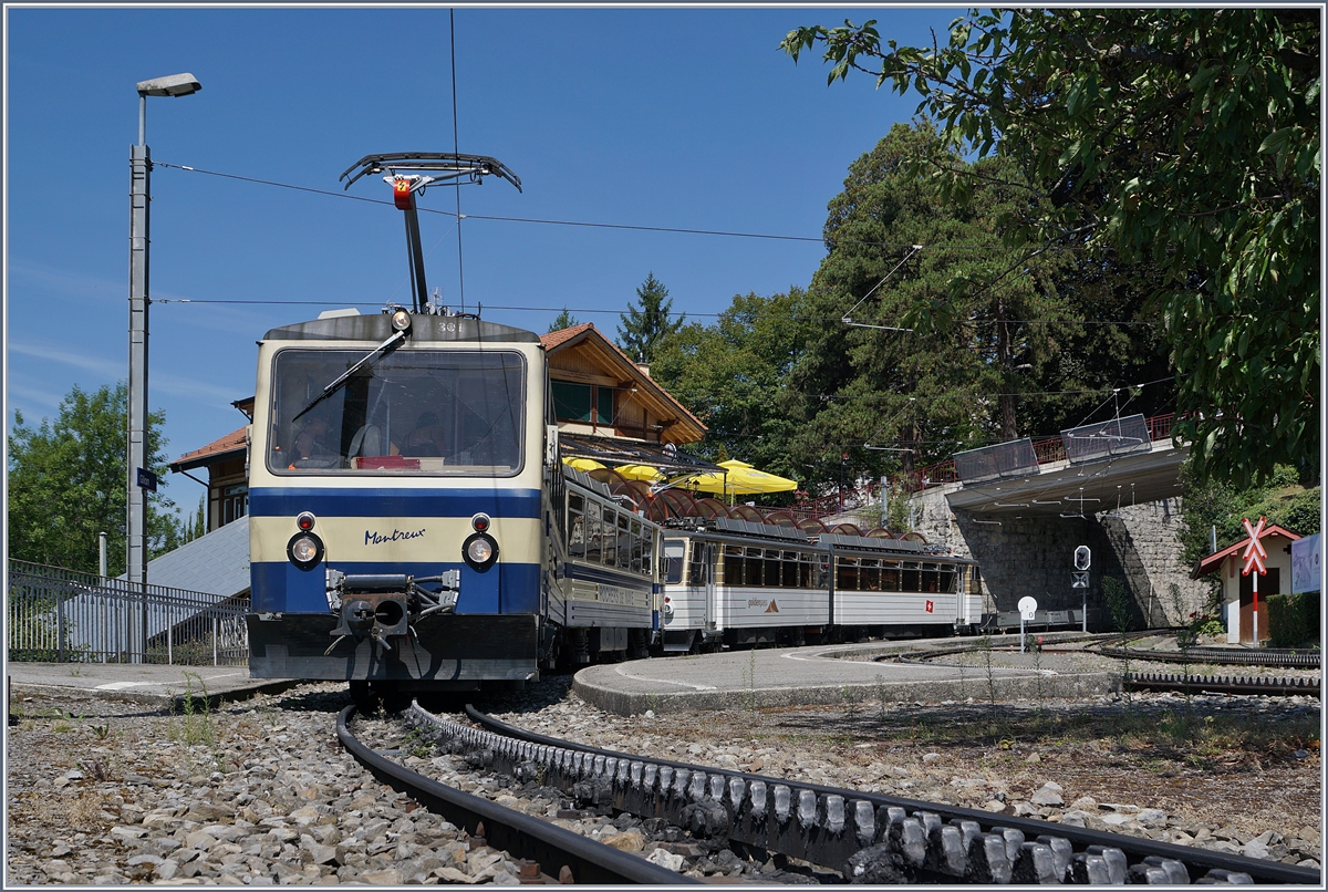 Der Rochers de Naye Bhe 4/8 301  Montreux  und der Bhe 4/8 305 warten in Glion auf die Weiterfahrt nach Montreux. Das Bild entstand auf dem Verbindungsweg zum Bahnübergang.
2. Aug. 2017