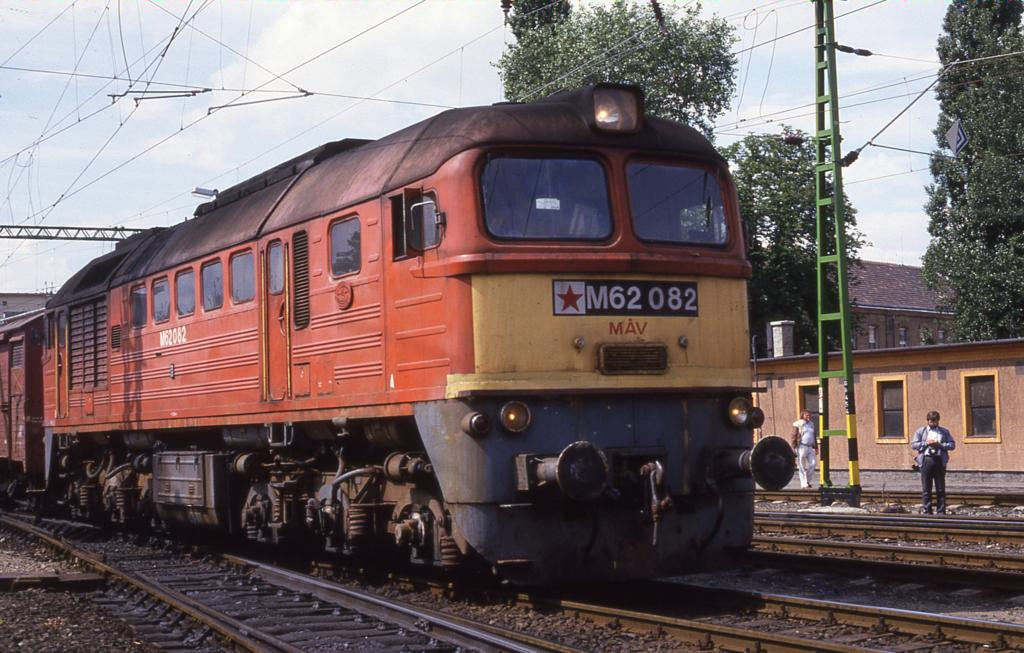 Der rote Stern in der Nummer ist ein untrgliches Zeichen der Zeit! Es 
herrscht noch der kalte Krieg zwischen den Blcken in Ost und West.
Am 18.6.1987 fhrt hier die MAV Diesellok M 62082 
mit einem Gterzug in Sopron ein. 