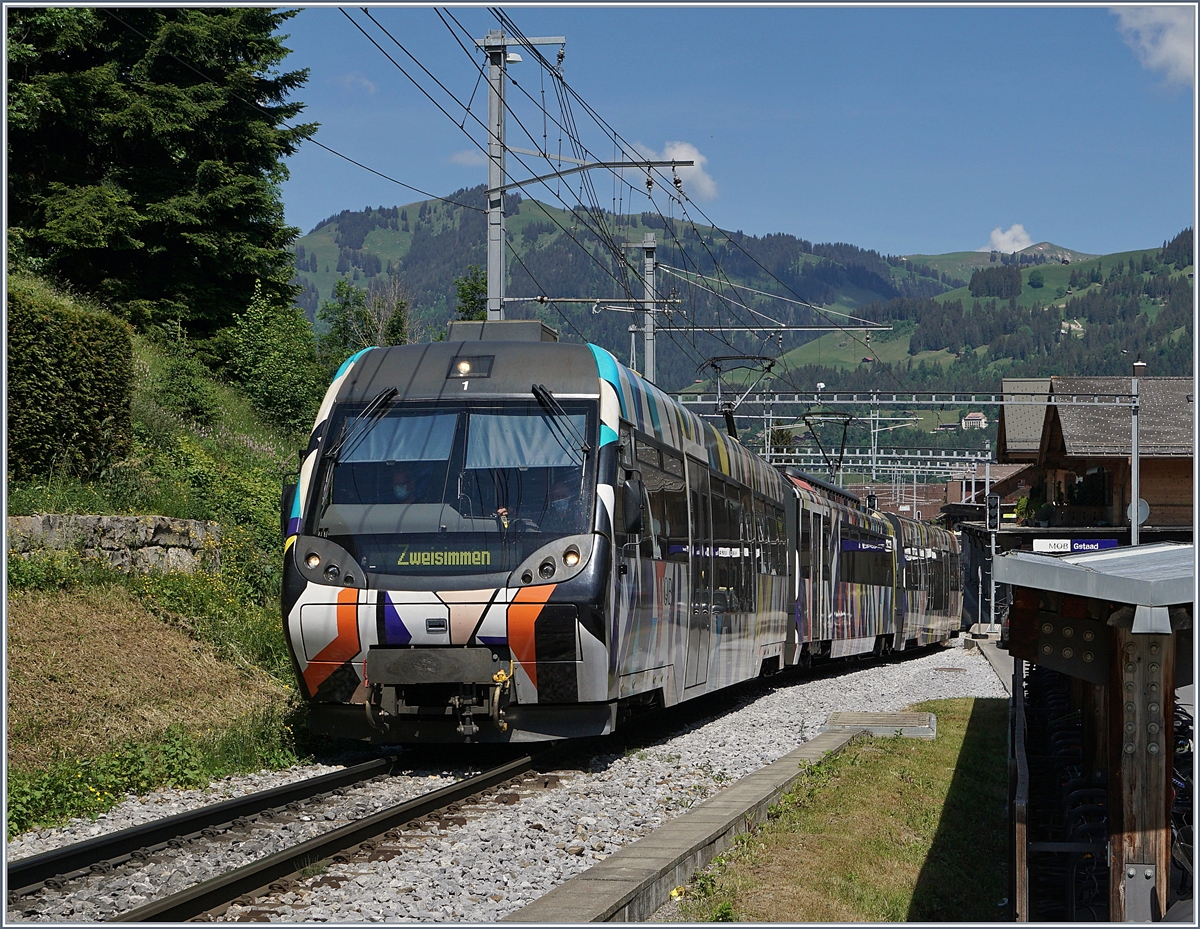 Der von Sarah Morris als  Monarch  gestaltete MOB Be 4/4 5001 mit seinen Steuerwagen ABt 341 und Bt 241 als Regionalzug 2418 von Rougemont nach Zweisimmen unterwegs und verlässt nach einem kurzen Halt Gstaad.

2. Juli 2020