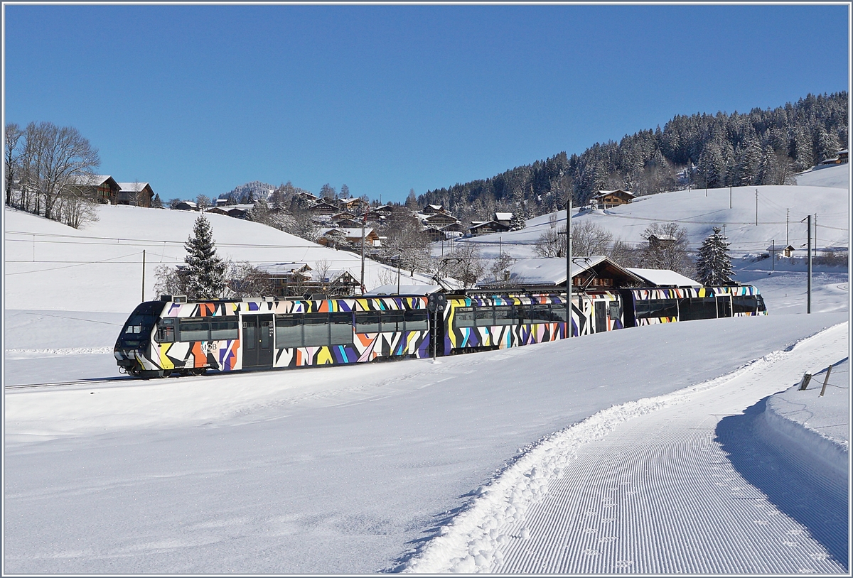 Der von Sarah Morris gestaltete Lenkerpendel  Monarch , bestehend aus ABt 341, Be 4/4 5001 und Bt 241, fährt als IR 2115 von Zweisimmen nach Montreux. Die Stammkomposition schein ausgefallen zu sein und der zeitlich nächstliegende Ersatz fand sich im  Monach . 
Das Bild entstand oberhalb von Gruben, als  Notschlachtung , nachdem ich lange bei Gruben auf den nicht kommen wollenden Zug gewartet hatte.
13. Feb. 2018