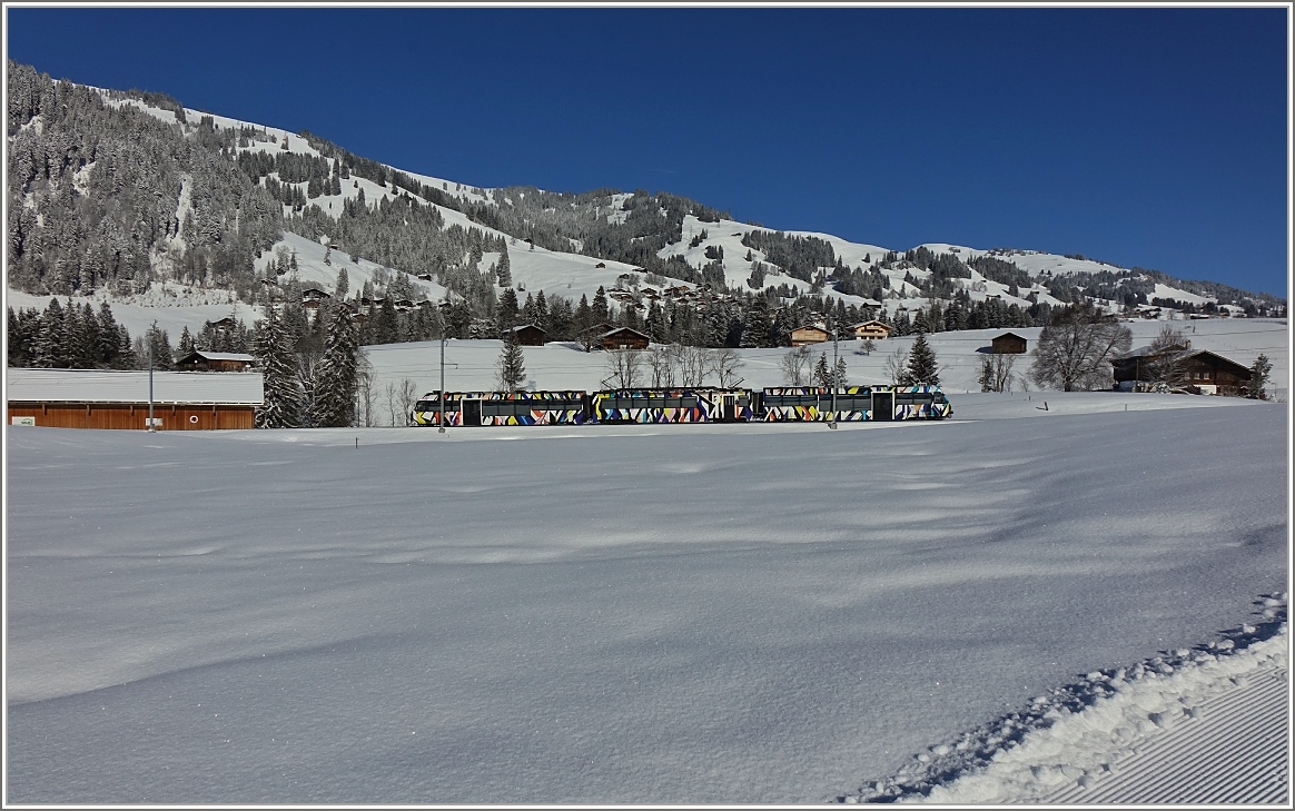 Der von Sarah Morris gestaltete Lenkerpendel  Monarch , bestehend aus ABt 341, Be 4/4 5001 und Bt 241, kurz vor Gruben.
(13. Februar 2018)