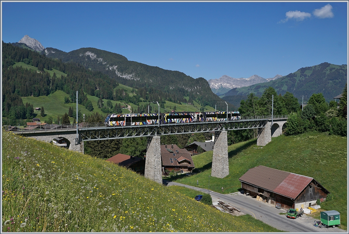 Der von Sarah Morris gestaltete MOB Lenkerpendel  Monarch  ABt 341 - Be 4/4 5001 - Bt 241 als Regionalzug 2531 Lenk - Rougemont auf dem 109 Meter langen Grubenbachviadukt kurz vor der Ankunft in Gstaad. 

2. Juni 2020